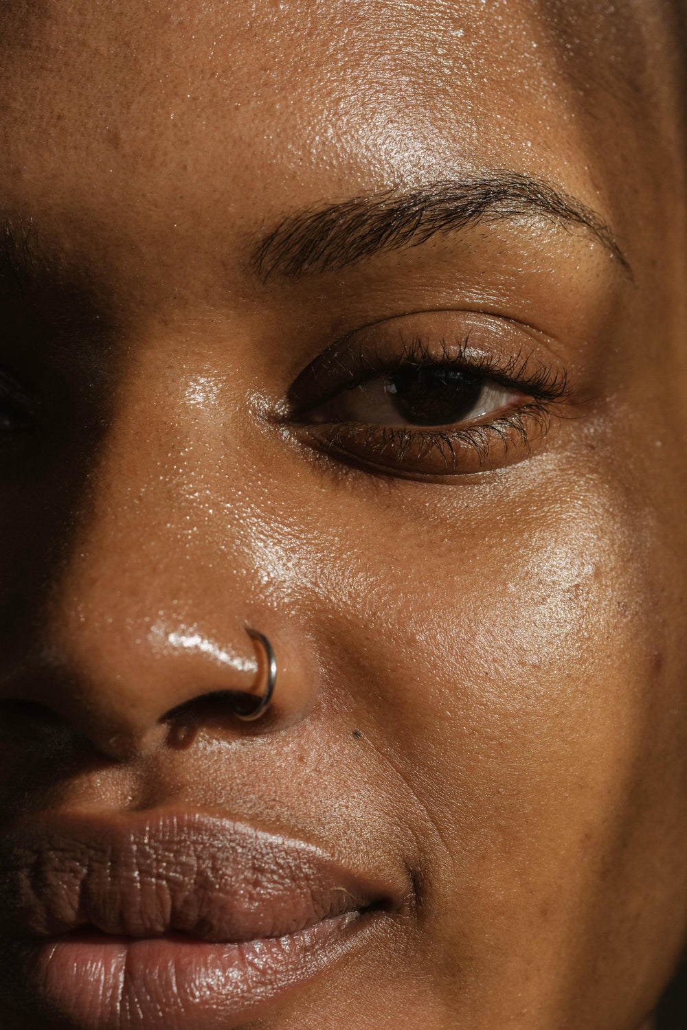 Gros plan d'un visage à la peau brillante et lumineuse, illustrant la peau grasse et déshydratée