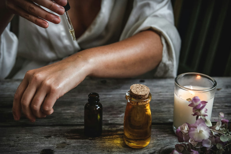 Femme appliquant un sérum exfoliant au compte-gouttes sur son avant-bras